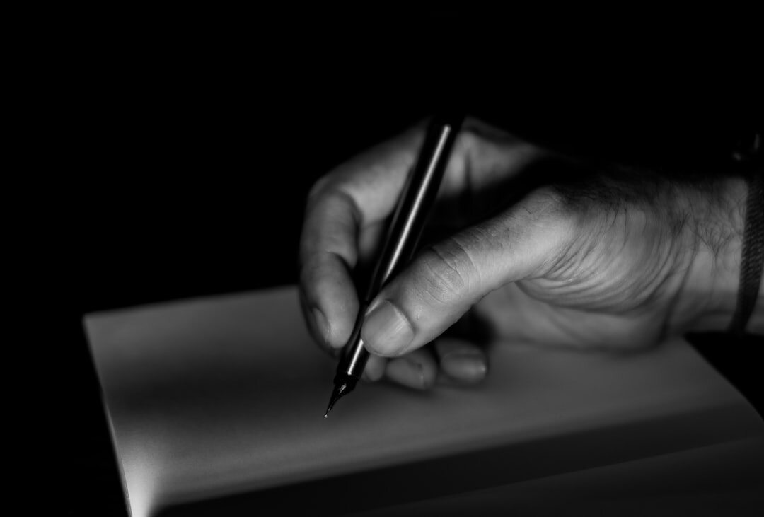 Close-up of hands signing a last will and testament document with a fountain pen